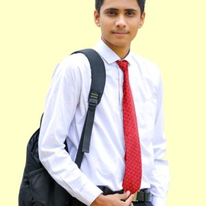 Young male student in formal school uniform with a backpack, looking confident.